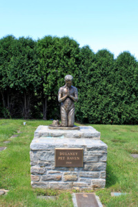 Pet Haven garden bronze statue of boy praying near pet graves.