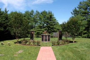 Pet Sanctuary garden entrance with pathway and monuments and flowers.