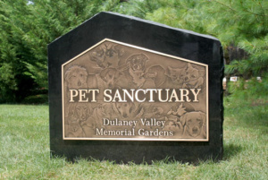 Pet Sanctuary entrance sign in bronze and granite with images of pets.